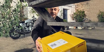 Jürgen Vogel holt Paket unter Treppe auf seinem Grundstück hervor.